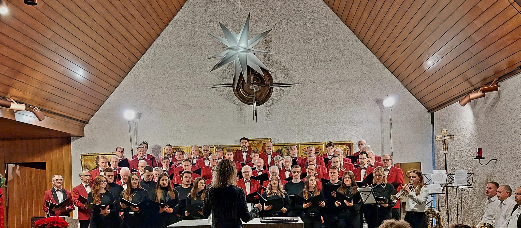 -11- Die beiden Ch&ouml;re singen das &auml;lteste Weihnachtslied, dirigiert von Anna Gr&auml;b. Daneben Solotrompeterin Valentina Knorr